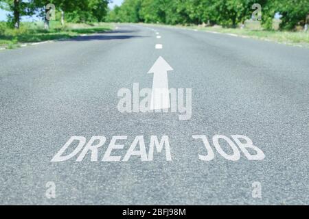 Text Traumjob mit Pfeilmarkierung auf Straßenbelag Stockfoto