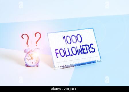 Textzeichen mit 1000 Followern. Geschäftsfoto, auf dem die Anzahl der Personen gezeigt wird, die jemand im Instagram Mini-Wecker neben einem Pape folgt Stockfoto