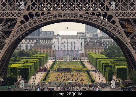 Blick auf den Parc de la Tour Eiffel durch den Gründungsbogen des Eiffelturms, Paris Stockfoto