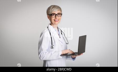 Konzept der medizinischen Beratung. Frau Arzt in Brille mit Laptop Stockfoto