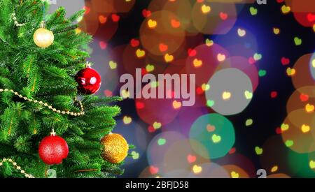 Geschmückter Weihnachtsbaum auf festlichem glänzenden Hintergrund Stockfoto