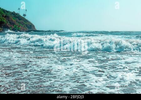 Strandantenne, Blick auf eine wunderschöne Strandantenne, die mit den blauen Wellen in die Küste rollt, Insel mit Palmen Hintergrund und sonnigen blauen Himmel in Ind Stockfoto