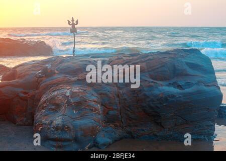 Shiva Face Rock Carving und Trident Totem am Vagator Beach, Goa, Indien. Schöner Sonnenuntergang Hintergrund. Nördlichster Strand von Bardez Taluka in Goa. Gegenposition Stockfoto