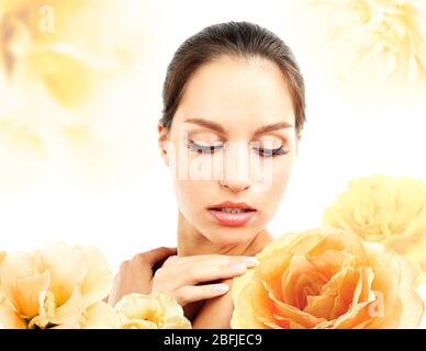 Schöne junge Frau und große orange Blüten isoliert auf weiß Stockfoto