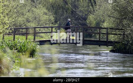 Eine Person geht über eine Brücke über den Fluss Itchen in der Nähe von Ovington in Hampshire. Stockfoto