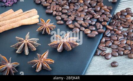 Zimtstangen, Sternanis und Kaffeebohnen. Gewürze und Lebensmittel auf Holzhintergrund. Zutaten für das Restaurant Stockfoto