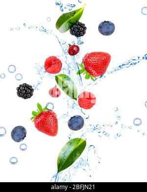 Frische Beeren und grüne Blätter mit Wasserspritzern, isoliert auf weiß Stockfoto