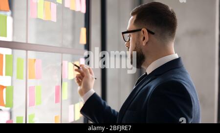 Männlicher Mitarbeiter, der sich im Büro mit kreativem Denken beschäftigt Stockfoto