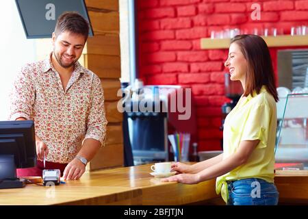 Der Kassierer bedient die Kunden an der Kasse im Café Stockfoto