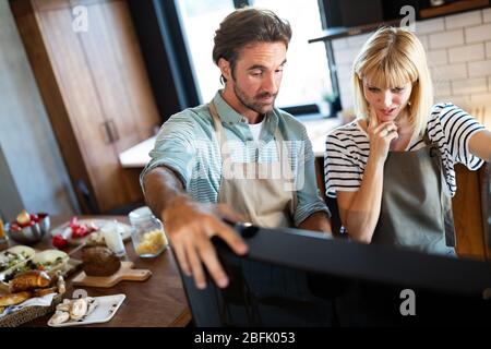 Glückliches junges Paar kochen gemeinsam in der Küche zu Hause. Stockfoto