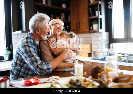 Happy grandchildrens Mädchen frühstücken mit ihren Großeltern Stockfoto