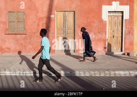 Die Einheimischen schreiten durch die Altstadt von Saint Louis, Senegal. Stockfoto