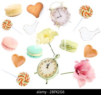 Makronen, Kekse, Süßigkeiten, Uhren, Blumen und Vögel auf Weiß isoliert Stockfoto