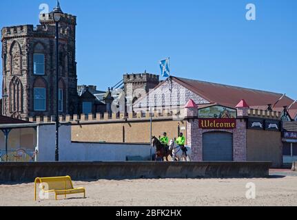 Portobello Beach, Edinburgh, Schottland. April 2020. Freundliche berittene Polizei mit Pferden namens Logie und Edinburgh die weiße, ihre tägliche Patrouille der Promenade und Strand bei hellem sonnigem Wetter weniger Menschen als gestern, als die Coronavirus Lockdown weiter, Auf der Promenade waren allerdings Radfahrer unterwegs, was mehr war als am Strand, obwohl der Sandstrand für Wanderer leichter sein kann, sich selbst zu isolieren. Temperatur von 10 Grad bei einem ENE-Wind von 17km/h potenzielle Böe von 33km/h. Quelle: Arch White/Alamy Live News. Stockfoto