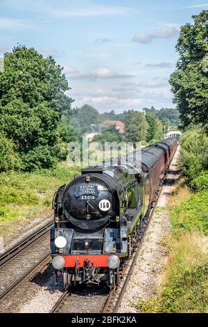 BR 'Merchant Navy' 4-6-2 No. 35018 'British India Line' führt in der Nähe von Chertsey Station, Surrey, UK Stockfoto