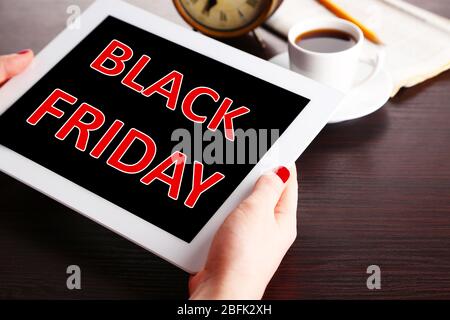 Hände halten Tablet mit Black Friday Text auf dem Bildschirm, Black Friday Konzept Stockfoto