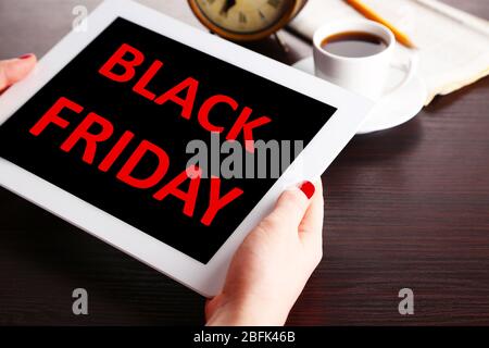 Hände halten Tablet mit Black Friday Text auf dem Bildschirm, Black Friday Konzept Stockfoto