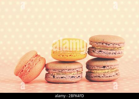 Leckere Makronen auf rosa Tupfen Hintergrund Stockfoto