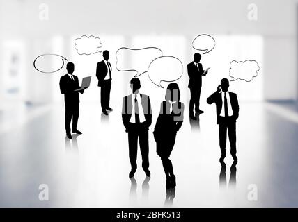 Silhouetten von Geschäftsleuten mit Sprechblase auf Bürohintergrund Stockfoto