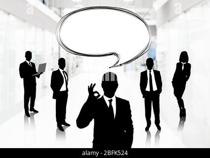 Silhouetten von Geschäftsleuten mit Sprechblase auf Bürohintergrund Stockfoto