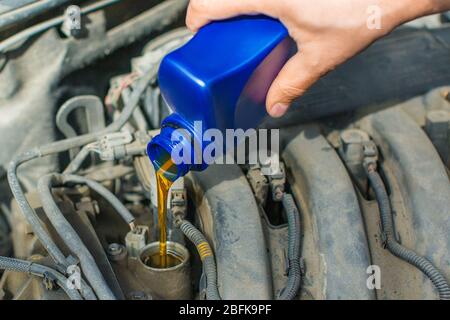 Nahaufnahme eines männlichen Hands füllen einen Motor mit Öl. Autoservice. Stockfoto