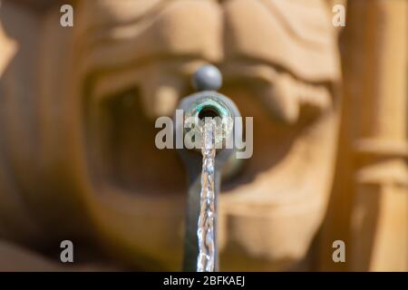 Vorderansicht Nahaufnahme von Wasser aus einer Fontäne Düse kommt aus einem geformten Mund Stockfoto