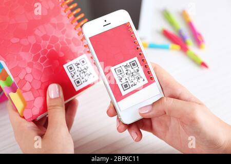 Frau scannt Gutschein-Code mit Handy aus nächster Nähe Stockfoto