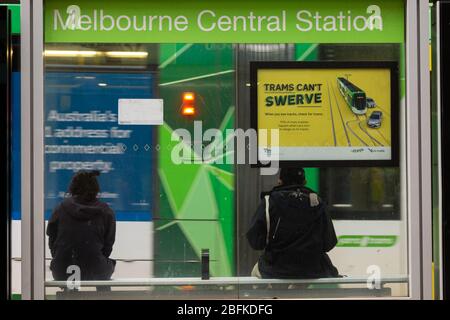 Melbourne, Australien, 19. April 2020. Zwei Personen warten während der Coronavirus-Krise in Melbourne, Australien, an einem Straßenbahnstop. Kredit: Dave Hewison / Alamy Live News Stockfoto