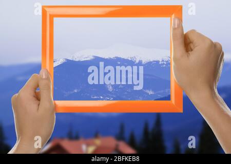 Frau Hände halten leeren Rahmen auf Natur Hintergrund Stockfoto