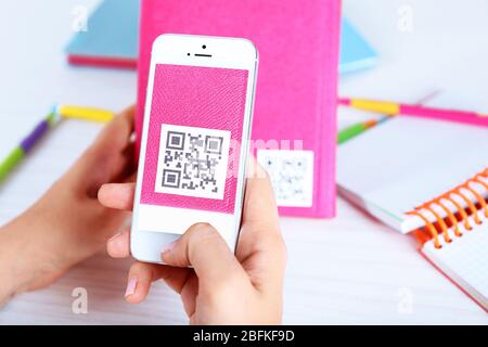 Frau scannt Gutschein-Code mit Handy aus nächster Nähe Stockfoto