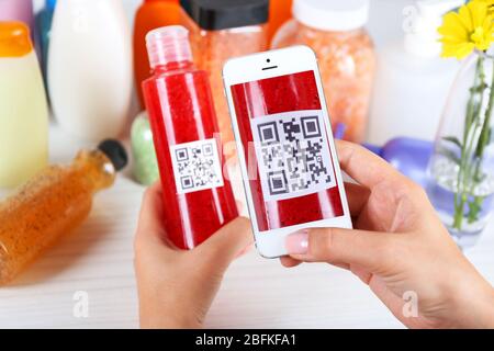 Frau scannt Gutschein-Code mit Handy aus nächster Nähe Stockfoto