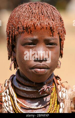 Porträt einer jungen Frau des Hamer Stammes das Haar ist mit Ockerschlamm und tierischem Fett überzogen, fotografiert im Omo River Valley, Äthiopien Stockfoto