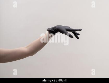 Ästhetische weibliche Hand in einem schwarzen Handschuh. Stockfoto