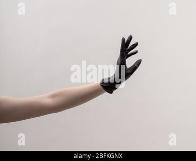 Ästhetische weibliche Hand in einem schwarzen Handschuh. Stockfoto