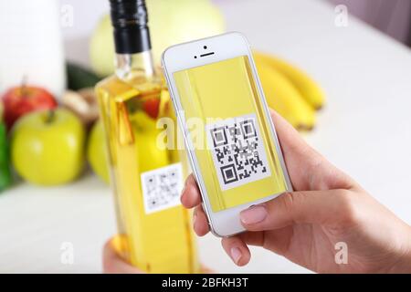 Frau scannt Gutschein-Code mit Handy aus nächster Nähe Stockfoto