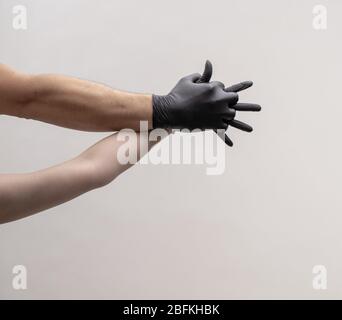 Männliche und weibliche Hand in schwarzen Handschuhen. Halten Sie sich gegenseitig. Stockfoto