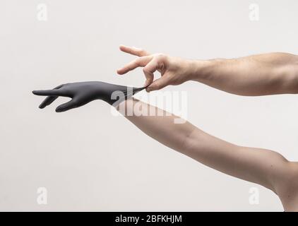 Weibliche Hand in einem schwarzen Silikonhandschuh Stockfoto