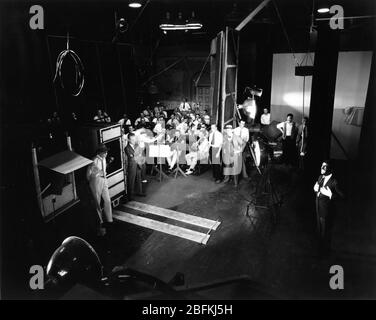 Regisseur LLOYD BACON und Kamerateam in Booth Filmen AL JOLSON singen in Blackface mit Full Orchestra am Set Candid für DEN SINGENDEN NARREN 1928 Regisseur LLOYD BACON The Vitaphone Corporation - Warner Bros. Stockfoto