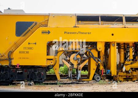 Pranburi, Thailand - 14. Januar 2019, der gelbe Zug Plasser theurer, die Zug Mieter Auto auf seiner Schiene während des Tages in Thailand geparkt. Stockfoto