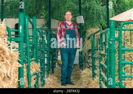 Frau Bauer auf einer Ziegenfarm posiert vor dem goatpen Stockfoto