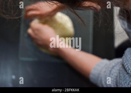 Eine Frau, die Teig knetet, der für selbstgebackenes Brot verwendet wird Stockfoto