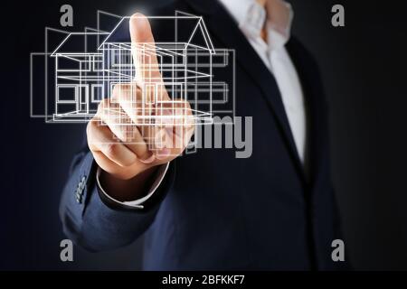 Immobilienangebot. Geschäftsmann mit einem künstlichen Modell des Hauses Stockfoto
