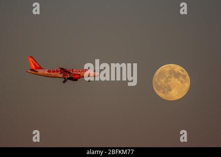 Flugzeug fliegt vor dem Mond Stockfoto