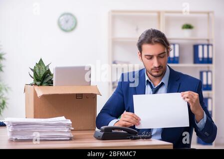 Junger Mann, der von seinem Arbeitsplatz aus gefeuert wird Stockfoto