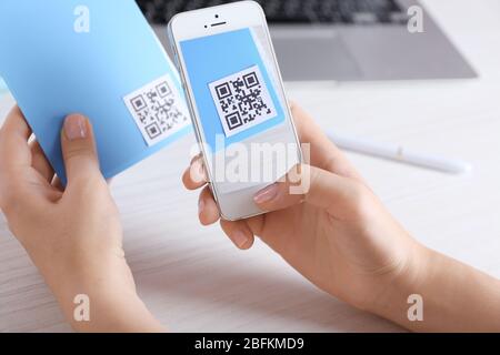 Frau scannt Gutschein-Code mit Handy aus nächster Nähe Stockfoto