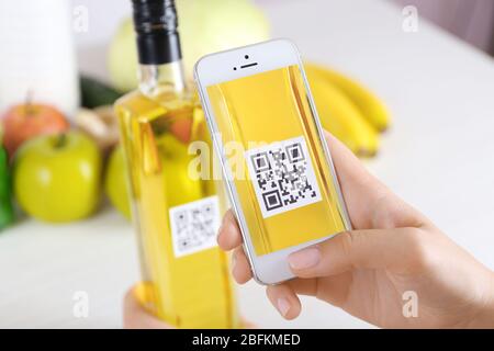 Frau scannt Gutschein-Code mit Handy aus nächster Nähe Stockfoto