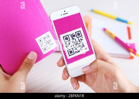 Frau scannt Gutschein-Code mit Handy aus nächster Nähe Stockfoto