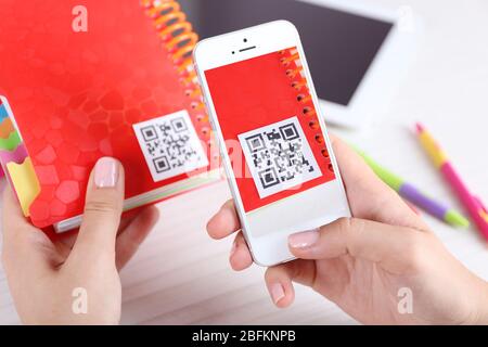 Frau scannt Gutschein-Code mit Handy aus nächster Nähe Stockfoto