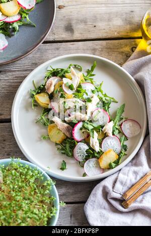 Frischer Salat mit Radieschen, Kartoffeln, Rucola und Makrele oder Thunfisch. Stockfoto