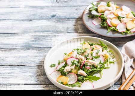 Frischer Salat mit Radieschen, Kartoffeln, Rucola und Makrele oder Thunfisch. Stockfoto